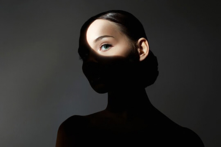Woman with one eye illuminated to represent visual suppression and binocular imbalance