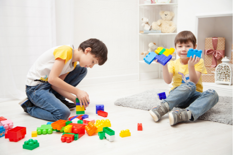 Children playing with building blocks to support visual skills, spatial awareness, and eye-hand coordination