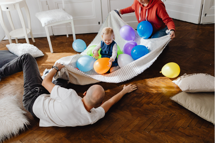 Family playing with balloons at home to build eye-hand coordination, focus, and visual tracking