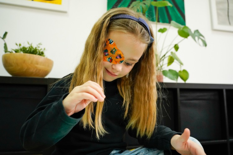 Child wearing an eye patch during amblyopia treatment at home.